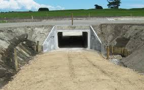 Concrete box culvert under construction beneath a dirt road