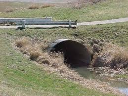 Culvert pipe passing under a road with a guardrail above