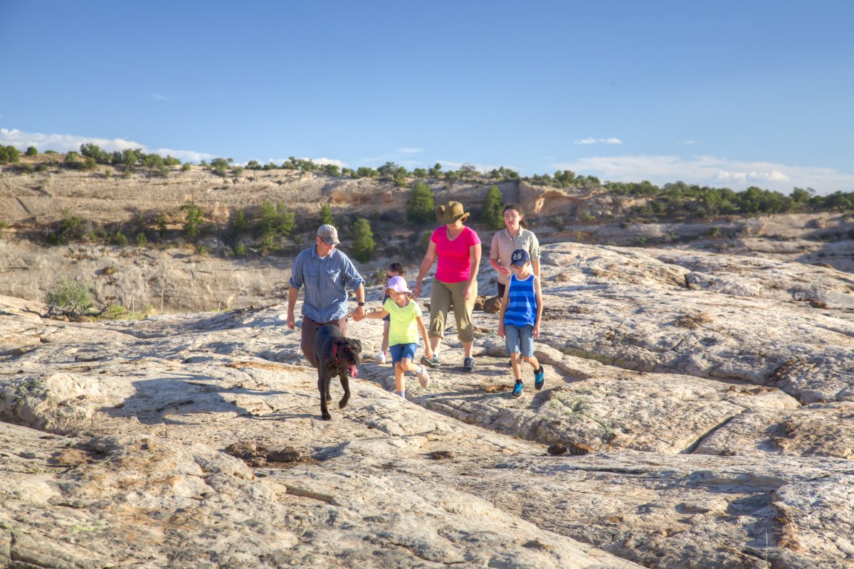 A family hiking across slickrock at Indian Creek in southeastern Utah